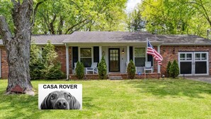 A two-story house with a front porch, a garage, and a well-maintained lawn. - Casa Rover - Pet Friendly w/ Fenced-in Yard, Family Friendly, Mins to Downtown Nashville (Nashville)
