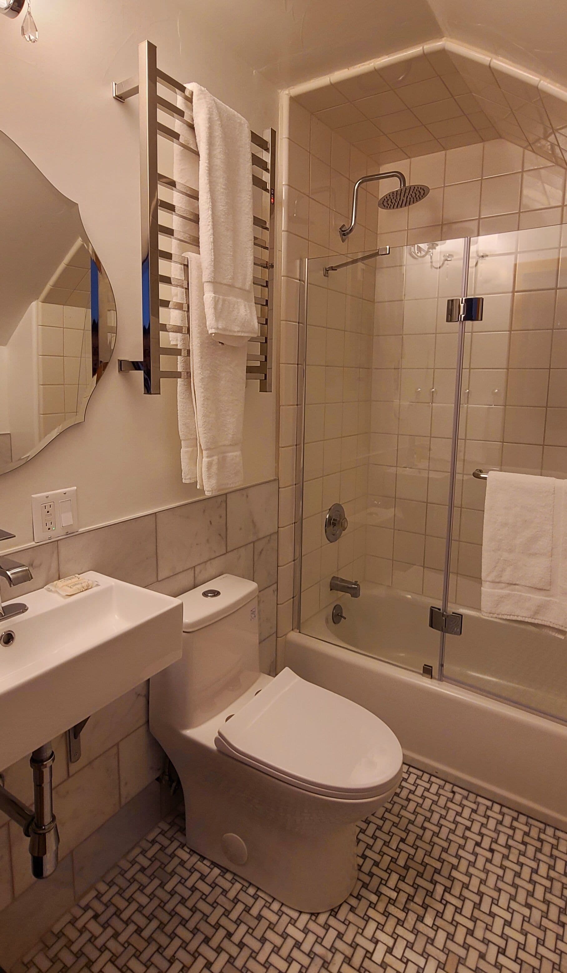 A modern bathroom with a toilet, sink, and shower.
