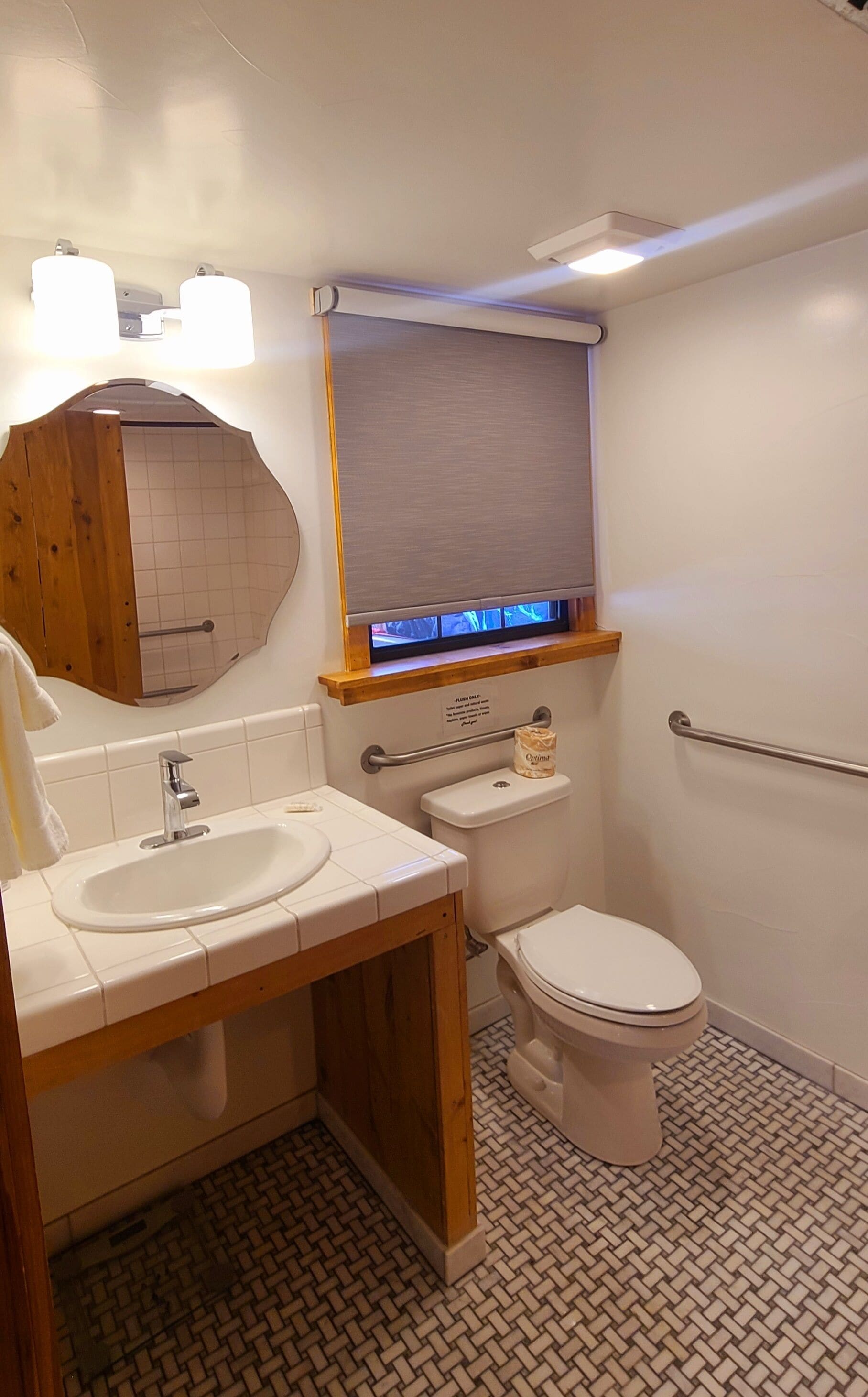 Un baño con lavamanos, inodoro y espejo de tocador.