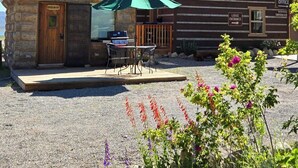 A rustic lodge with a wooden exterior, a metal roof, and a gravel driveway.