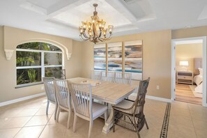 Enjoy meals in this inviting dining area with a light table, comfortable chairs, and a beautiful view of the surrounding greenery.
