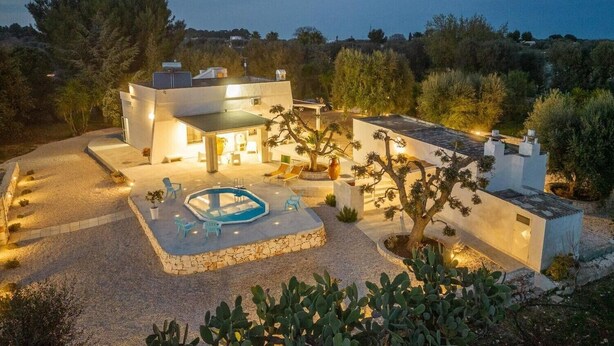 A modern villa with a swimming pool, outdoor seating, and a well-maintained garden.