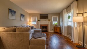 Una sala de estar con chimenea, un conjunto de sofá y una lámpara de pie.