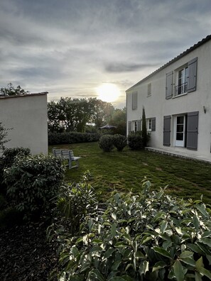 A residential building with a well-maintained lawn and a patio area.