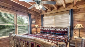 A wooden cabin bedroom with a bed, a ceiling fan, and a window with blinds. - E.Z drive! WOW VIEWS, hotTUB 🎱 POOL TABLE, fireplace Close to Gatbg & Dollywood (Sevierville)