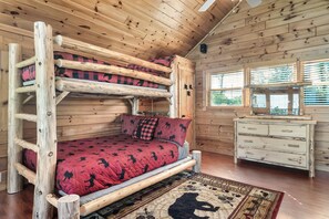 A bunk bed with a red patterned bedspread, a wooden dresser, and a window with blinds. - E.Z drive! WOW VIEWS, hotTUB 🎱 POOL TABLE, fireplace Close to Gatbg & Dollywood (Sevierville)