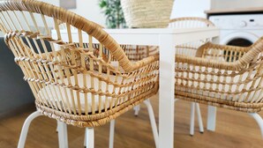 A dining area with two wicker chairs and a white table. - Global Vacacional: Apartment on the beach of Canet d'en Berenguer (Canet d´en berenguer)