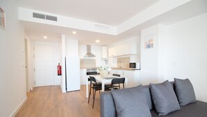A modern apartment with a living room, kitchen, and dining area.