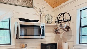 A kitchen with a microwave, toaster, and wooden cabinets.