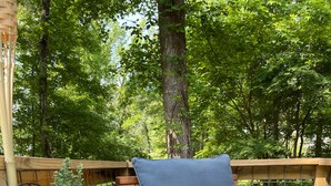 A wooden deck with a built-in bench and a potted plant.