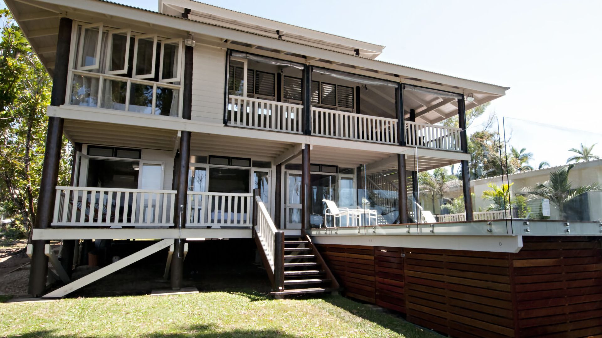 A two-story building with balconies, a covered outdoor area, and a pool.