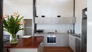 Eine moderne Küche mit einer Holz Arbeitsplatte, Edelstahlgeräten und hellen Schränken.