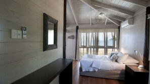 A bedroom with a bed, bedside table, and a window with curtains.