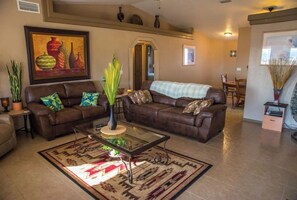 Relax in a stylish living space with a comfortable sofa, coffee table, and vibrant artwork.