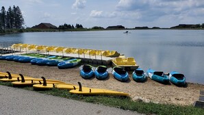 A lakeside area with rows of yellow and blue paddle boats lined up on the shore. - Seven Springs Mtn. Villas Condo - Ski, Golf, Hike, Sporting Clays, & Relaxation! (Champion)