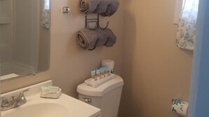 Un baño con inodoro, lavamanos y barra para toallas.