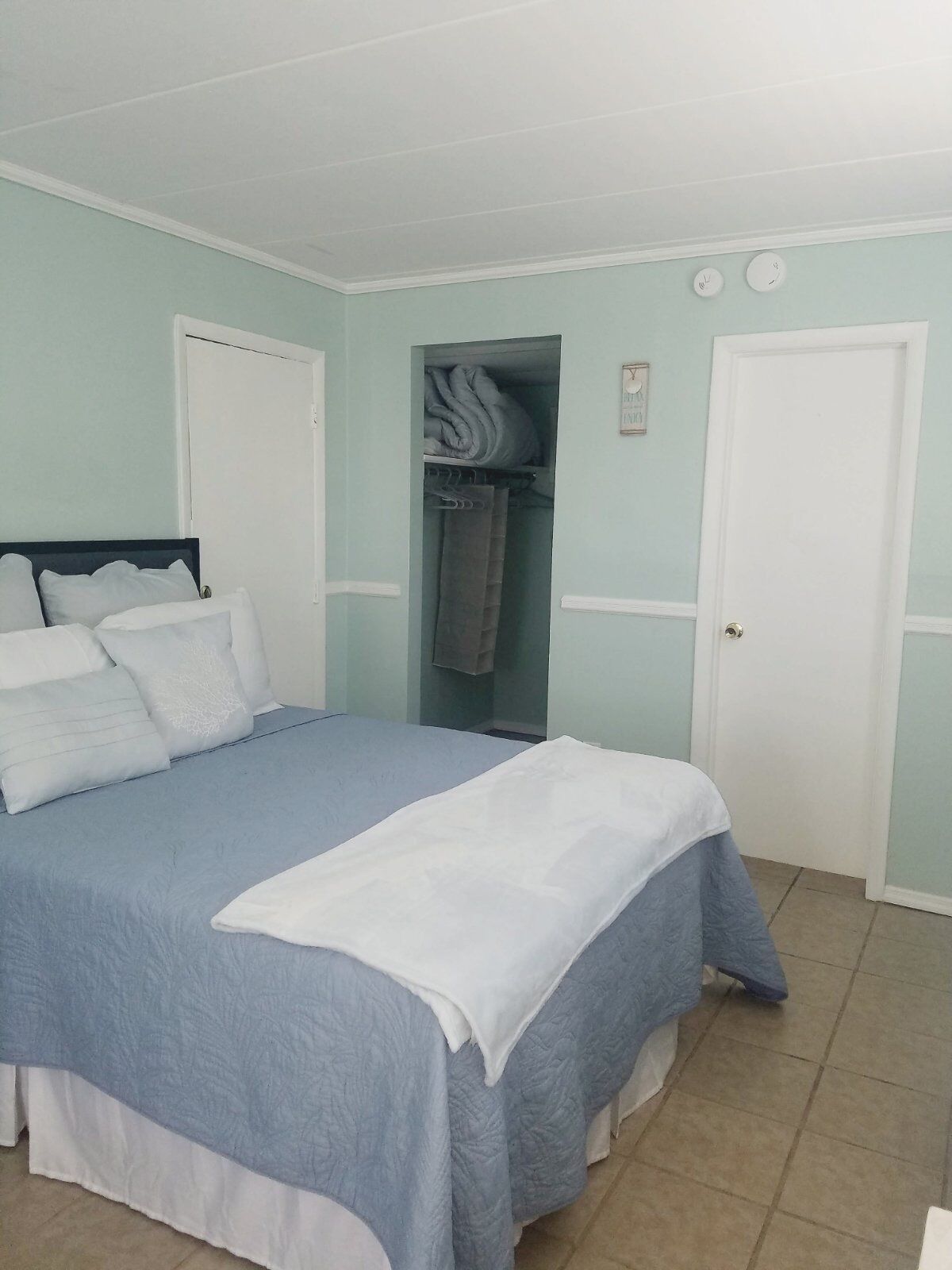 A bedroom with a bed, a closet, and a door.