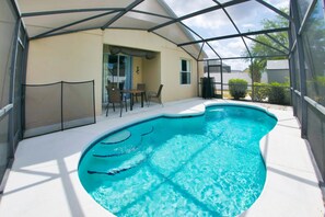 A swimming pool with a covered patio area. - 5/4 Pool home located in Sunset Ridge Community! (Davenport)