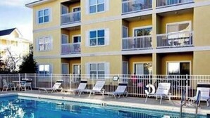 A multi-story building with balconies and a swimming pool. - Great cozy beach getaway (Santa Rosa Beach)