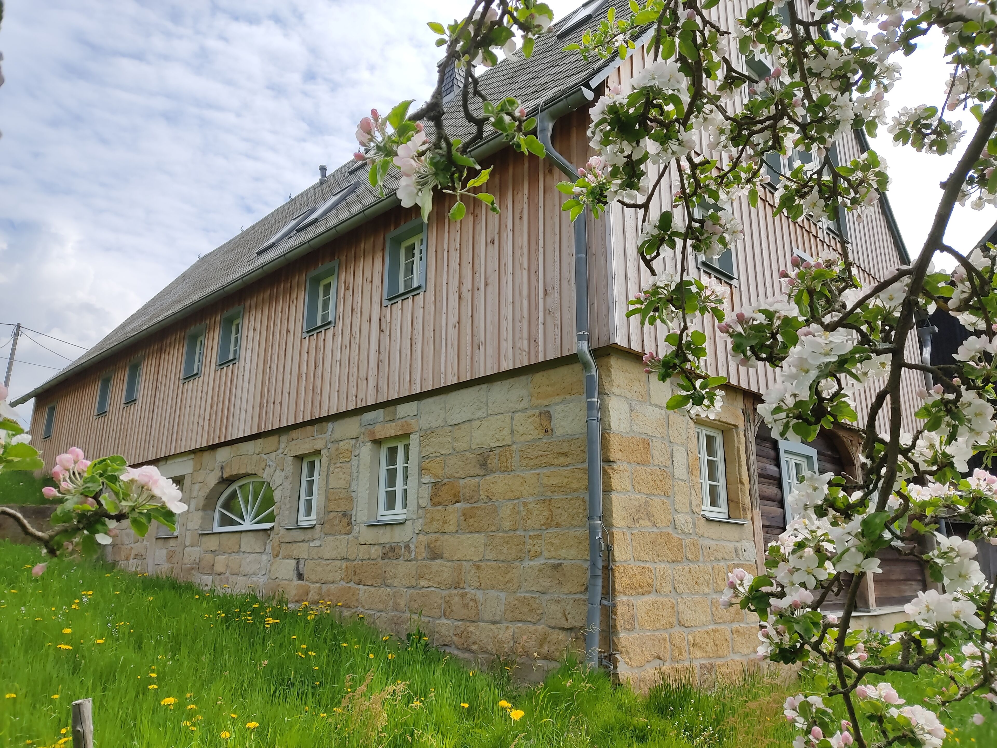 Un bâtiment en bois avec des murs en pierre et de nombreuses fenêtres.