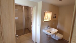Ein Badezimmer mit Dusche, Toilette und Waschbecken.
