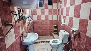 Un baño pequeño con lavamanos, inodoro y calentador de agua.