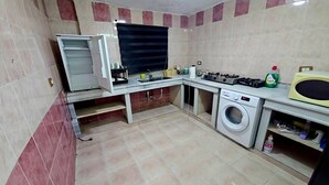 Cocina compacta con lavadora integrada, estufa y microondas.