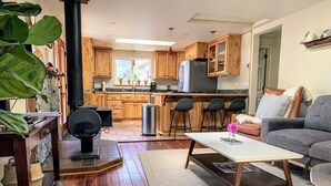 A modern kitchen with wooden cabinets, a central island, and a large window. - Coastal Refuge, *Hot Tub,* Close to Town. (Trinidad)