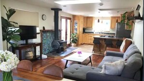 A living room with a sofa, TV, and dining area with a table and chairs. - Coastal Refuge, *Hot Tub,* Close to Town. (Trinidad)