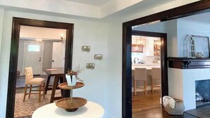A spacious living area with a modern chandelier, a dining table with chairs, and a fireplace. - Gorgeous, Fully Remodeled Open Floor-Plan! (Pontiac)