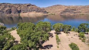 A campsite with tents, a lake, and rocky hills. - RV spot on the River Unit C -minutes from Gorge concerts (Quincy)
