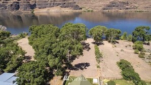 Un terrain de camping avec des tentes, un lac et des collines rocheuses.
