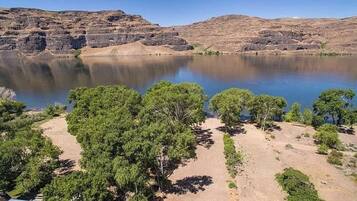 A campsite with tents, a lake, and rocky hills.