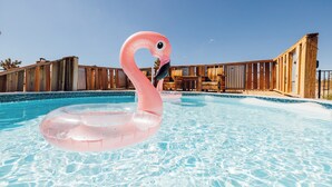 A swimming pool with a pink flamingo float. - Desert Oasis • Hot Tub, Pool, Arcade & Hammocks • Fenced 2 Acres • Joshua Trees (Yucca Valley)