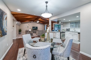 A modern kitchen with white cabinets, stainless steel appliances, and a large window.