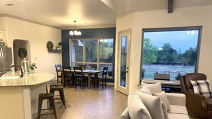 Una cocina moderna con encimera de granito y un comedor con un amplio ventanal.