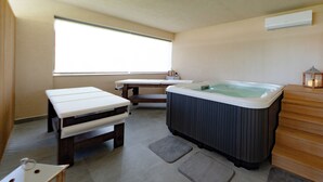 Ein Spa-Raum mit Whirlpool, einer Holzbank und einem kleinen Tisch.