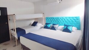 Habitación de hotel con literas, una cama individual y un ventilador de techo.