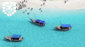 A beach with clear turquoise water and three boats with blue canopies. - Asante Sana Beachfront Hotel (Fukuchani)
