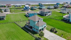 A coastal residential area with houses featuring balconies and waterfront views. - Savings Alert! Pet-Friendly: Spacious, Fenced Retreat, Views! Games!  Sleeps 14 (Crystal Beach)