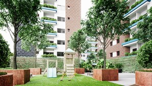 Ett bostadskomplex med flera hyreshus, en lekplats och välskött grönyta.
