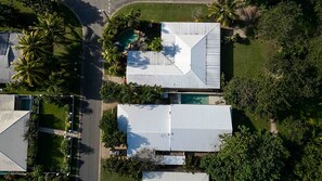A residential area with multiple houses, each featuring a swimming pool and surrounded by greenery.