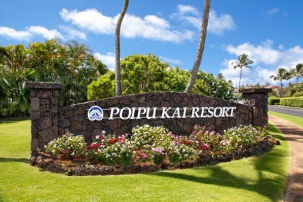 A stone sign with "POIPUI KAI RESORT" written on it, surrounded by a flower bed and palm trees. - Tropical Rendezvous Suite - Luxury Studio in tropical gardens with koi ponds. (Koloa)