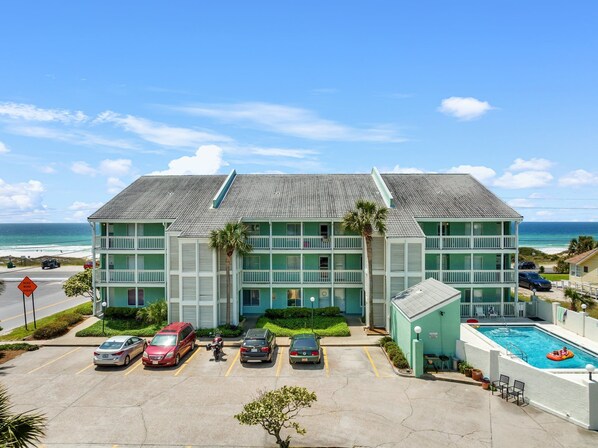 Un hotel de varios pisos con piscina y vistas al océano.