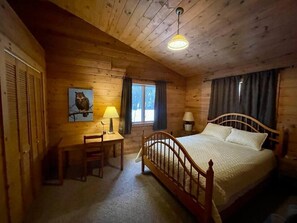 A wooden cabin bedroom with a bed, desk, chair, and a window. - Waterfront, Panoramic Views! White Star Point (Brussels)