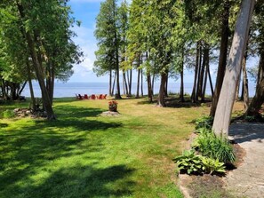 A grassy area with trees and a view of the water. - Waterfront, Panoramic Views! White Star Point (Brussels)