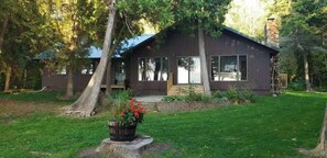 A modern house with a large window, a stone chimney, and a well-maintained lawn. - Waterfront, Panoramic Views! White Star Point (Brussels)