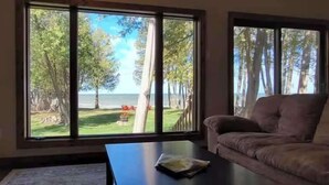 Una sala de estar con un ventanal amplio, un sofá y una mesa de centro.