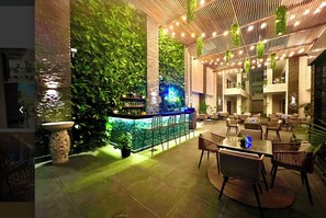 Relax in a contemporary space with a bar area featuring a variety of seating options and lush green gardens on the walls.