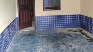 A room with a tiled floor, a door, a window with colorful tiles, and an air conditioning unit. - Pousada Devaneios (Ananindeua)
